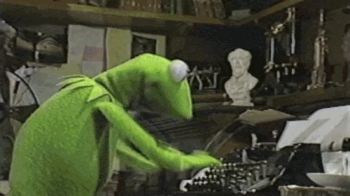 Kermit hammering on a typewriter